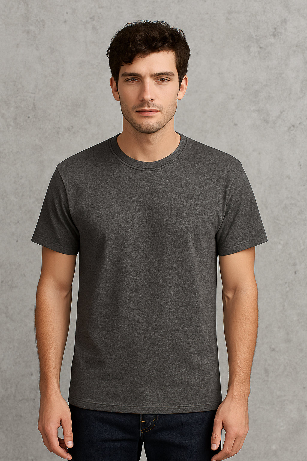 Man wearing a plain dark gray t-shirt against a gray background