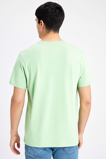 Person wearing a light green t-shirt on a white background