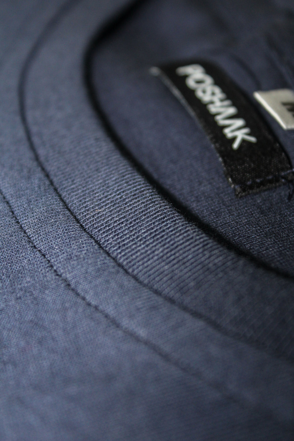 Close-up of a navy blue fabric with a visible brand label.