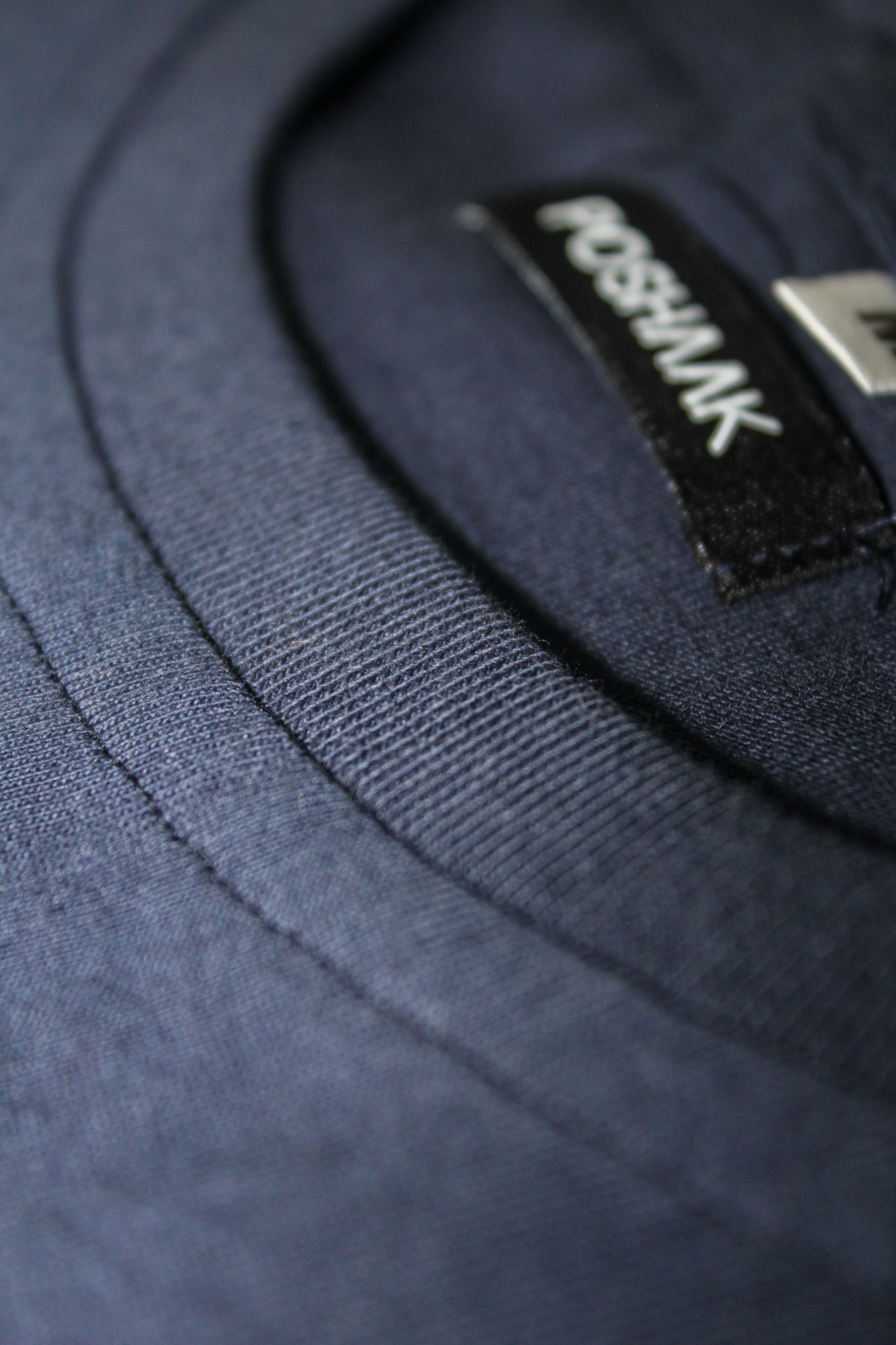 Close-up of a navy blue fabric with a visible brand label.