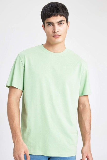 Person wearing a light green t-shirt on a white background